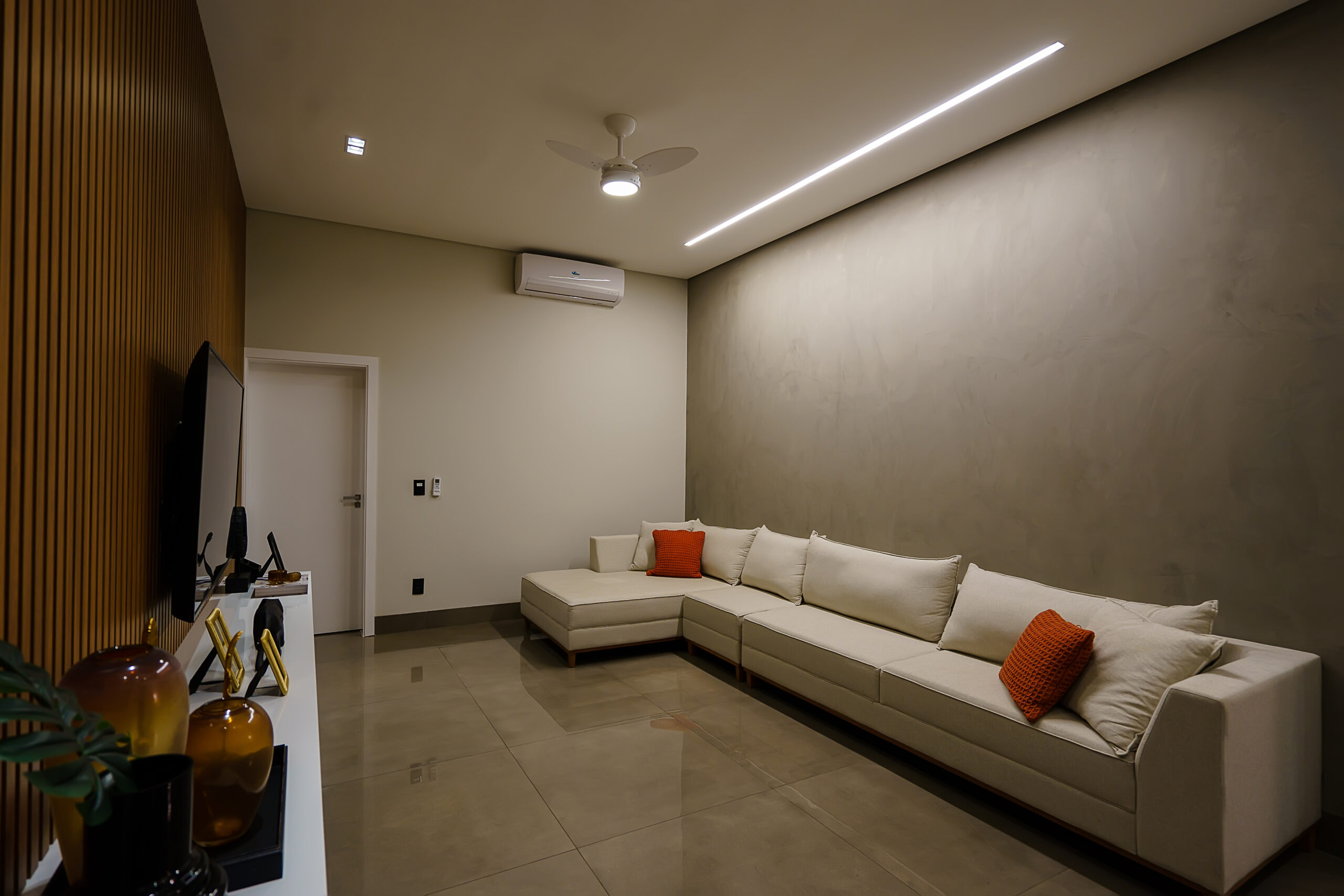 iluminação de uma sala de estar com perfil de LED, ventilador central e spots embutidos