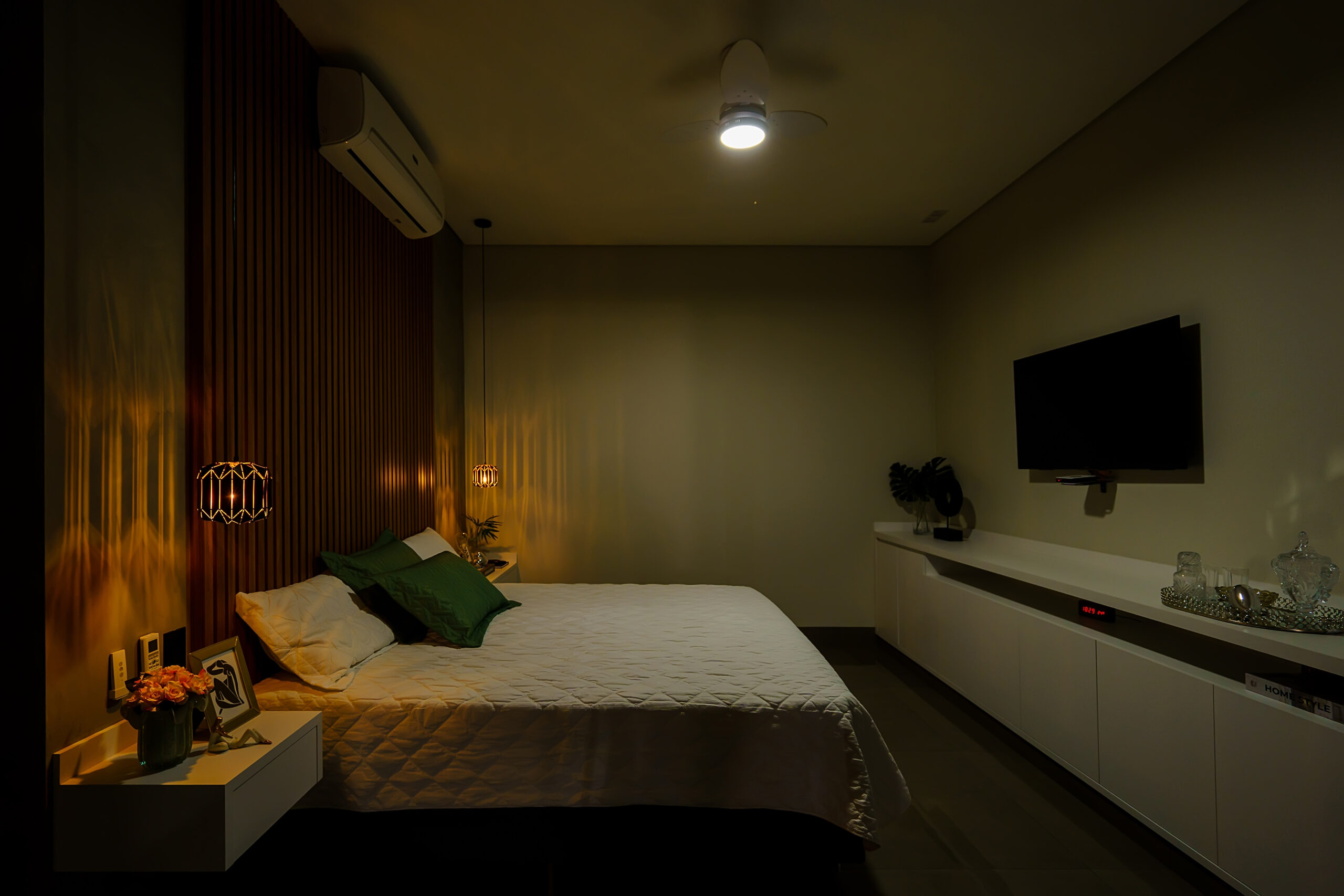 iluminação de uma suíte de casal, com ventilador no centro, pendentes MORI aos dois lados da cama, e perfis de LED no corredor.